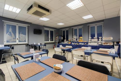 a dining room with blue tables and chairs at Twelve Hotel in Moncalieri