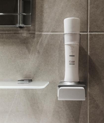 a white cup sitting on a shelf in a bathroom at Twelve Hotel in Moncalieri