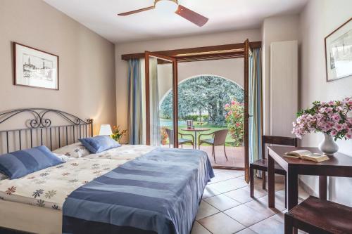 Schlafzimmer mit einem Bett und einem Tisch sowie einer Terrasse in der Unterkunft Garni Elena in Losone
