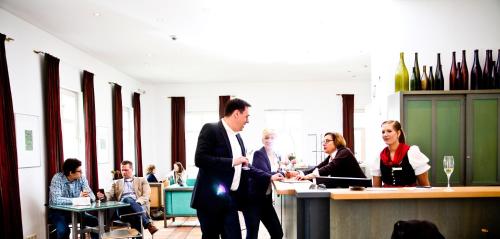 a man in a suit standing in a room with people at Breuer's Rüdesheimer Schloss in Rüdesheim am Rhein