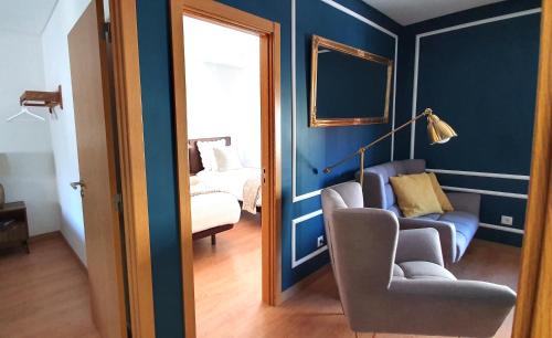een blauwe kamer met een stoel en een bank bij Afonso Galo Guest Apartments I in Almada