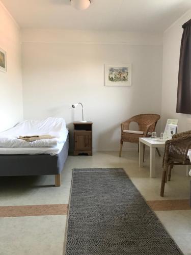 - une chambre avec un lit, une table et une chaise dans l'établissement Hillesgården, à Boarp