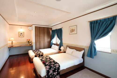 a hotel room with two beds and a window at Fantastic Story in Hirosaki
