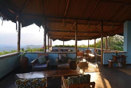 a living room with a table and chairs at Isunga Lodge in Kibale Forest National Park