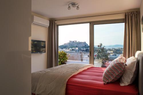 a bedroom with a red bed and a large window at Acropolis View Rooftop Apartment Athens in Athens