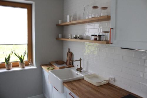 a small kitchen with a sink and a window at Monsieur Henri in Gronków