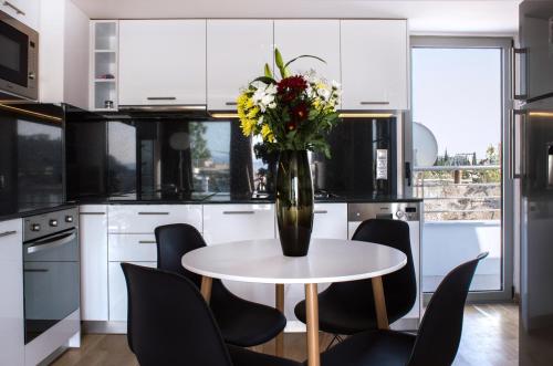a vase of flowers on a table in a kitchen at Acropolis View Rooftop Apartment Athens in Athens