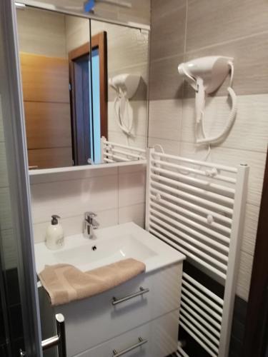 a white bathroom with a sink and a mirror at Haus Alexis in Faak am See