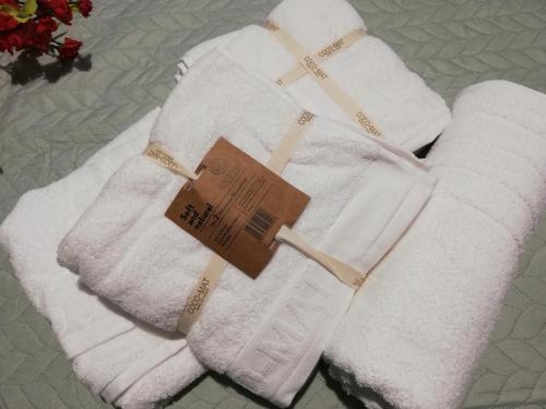 two white towels with a tag on them on a bed at TERRA LEMNIA in Moudhros