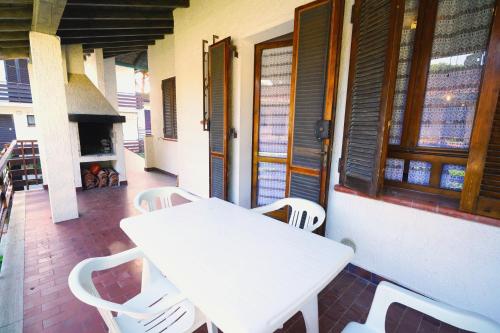 un tavolo bianco e sedie su una veranda con camino di Villetta Lagomare a Lido di Spina