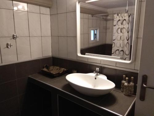 a bathroom with a sink and a mirror at Anthi Apartment in Paleo Tsifliki
