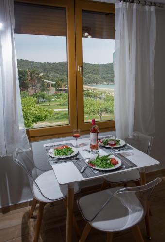 a table with two plates of food and a window at Rent House Karavi in Iraklitsa