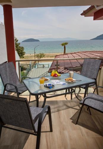a table and chairs on a balcony with a view of the ocean at Rent House Karavi in Iraklitsa