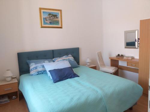 Schlafzimmer mit einem Bett mit blauer Bettwäsche und einem Stuhl in der Unterkunft Apartment Ana in Split