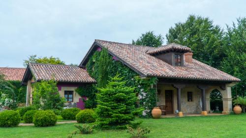 a house covered in ivy in a yard at Apartamentos Arcadia in Oreña