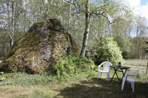 two chairs and a table next to a large rock at The Little Swedish Stuga in Hölö