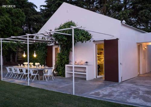 a white shed with a table and chairs in a yard at Casa da Serra in Azeitao