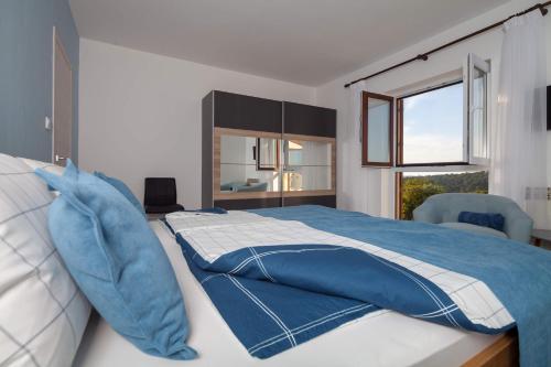 a bedroom with a large bed with blue pillows at Villa Nicole in Banjole