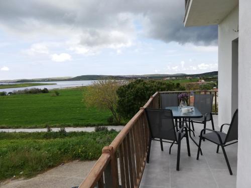 a balcony with a table and chairs and a view at TERRA LEMNIA in Moudhros
