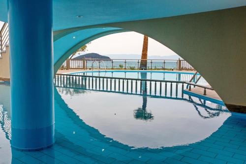 a swimming pool with a reflection of the ocean at Rent House Karavi in Iraklitsa