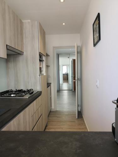 une cuisine avec cuisinière et un couloir dans l'établissement Le Splendid, à La Baule