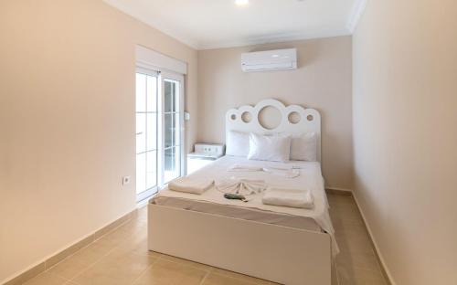 a white bedroom with a bed with a white headboard at White Star Antalya in Antalya