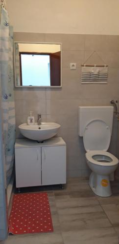 y baño con aseo blanco y lavamanos. en Room for 2 by the sea en Betina