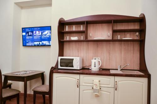 a room with a counter with a microwave and a table at Apartment nr. 8 in Odesa