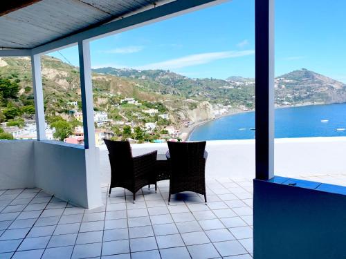 a balcony with a table and chairs and a view of the ocean at Villa Egidio in Ischia