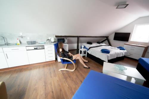 kobieta siedząca na krześle w sypialni w obiekcie Bluestars Family w Karlowych Warach
