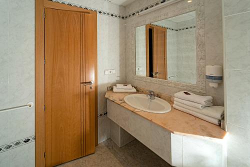 a bathroom with a sink and a mirror at Hotel Carabela Santa María in Mazagón