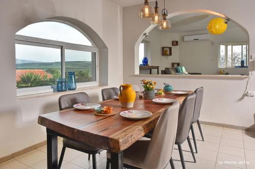 a dining room with a wooden table and chairs at Agama in Livnim