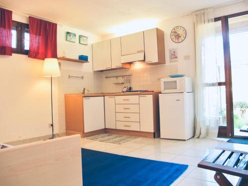 a kitchen with white cabinets and a white refrigerator at Monolocale Via Panoramica in Rio Marina