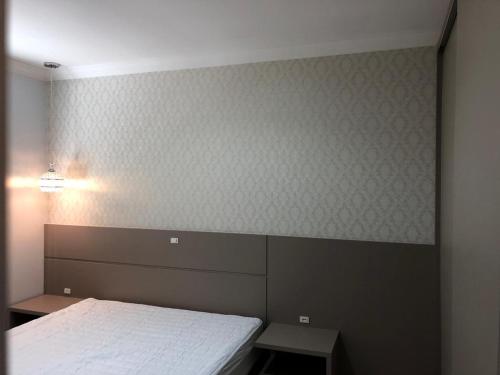 a bedroom with a bed and a wall with wallpaper at Apartamento 602 Edifício Thermas Palace in Piratuba