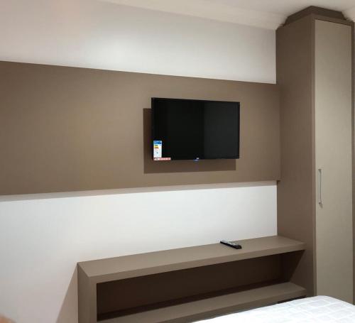 a room with a flat screen tv on a wall at Apartamento 602 Edifício Thermas Palace in Piratuba