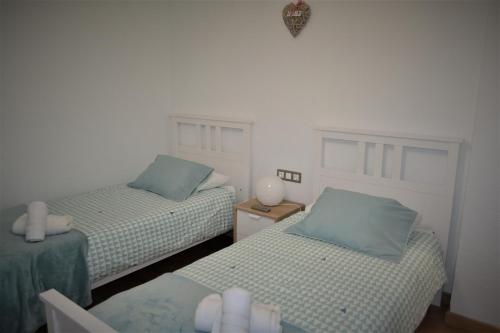a bedroom with two beds with blue pillows at Guimar Esencia en el corazón de la judería in Córdoba