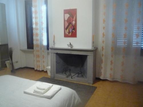a bedroom with a fireplace with two towels on a bed at Stanza in appartamento condiviso nel centro storico di Parma in Parma