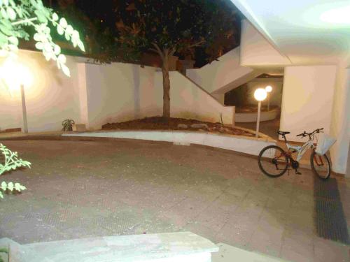 a bike parked next to a building with a tree at VILLA GARDA HOUSE 42 in Marina di Mancaversa