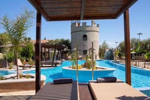 a pool at a resort with a tower at Villa Elia Resort in Lefkada