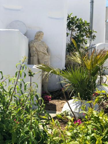 a statue sitting in a garden with plants at Apollonion house in Apollonia