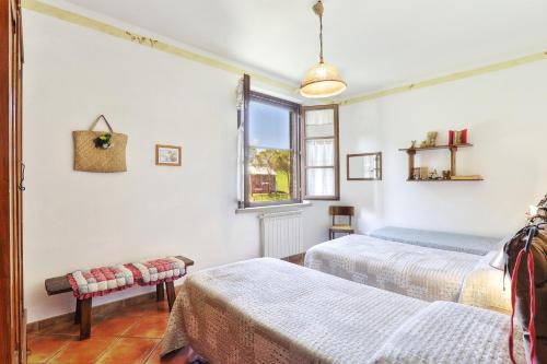 sypialnia z 2 łóżkami i oknem w obiekcie Appartamento Spiga - Agriturismo Le Selvole w mieście Pomarance