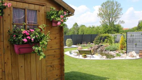 a garden with a bench and flowers in a yard at studios les Hortensias in Lillers