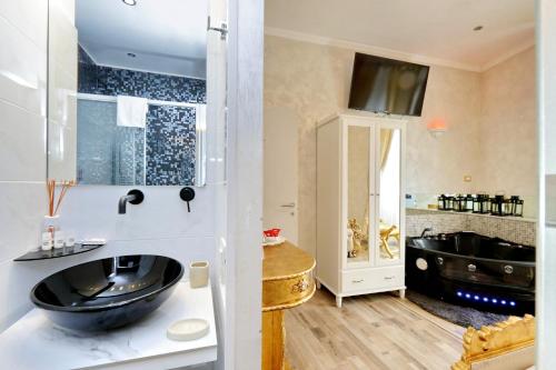 a bathroom with a black sink and a tub at Just Chilling Suite in Rome