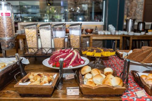 ベロオリゾンテにあるHilton Garden Inn Belo Horizonte Lourdesのさまざまな種類の食べ物が並んだテーブル