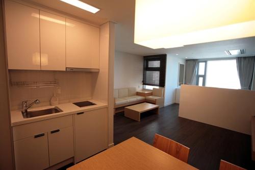 a kitchen with white cabinets and a dining room at Hanwha Resort Haeundae in Busan