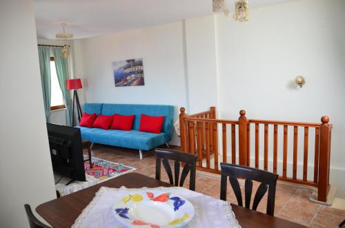 ein Wohnzimmer mit einem Tisch und einem blauen Sofa in der Unterkunft Two Stone Homes Hades in Marmaris