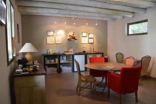 een eetkamer met een tafel en rode stoelen bij Les mésanges du Domaine du Moulin 31 in Trollat