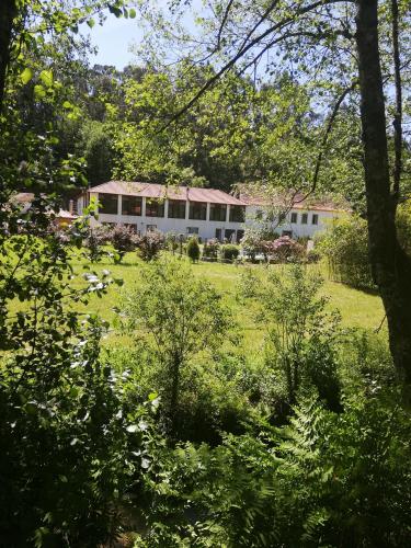 a house in the middle of a field with trees at Casa do Engenho in Caldas de São Jorge