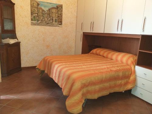 Mirella's House ViaVerona في أرديا: غرفة نوم مع سرير وبطانية برتقالية