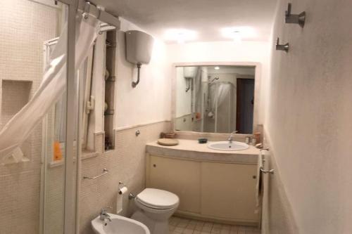 La salle de bains est pourvue de toilettes, d'un lavabo et d'un miroir. dans l'établissement Casa Vacanza la terrazza panoramica a 200 mt dal mare, à Simius
